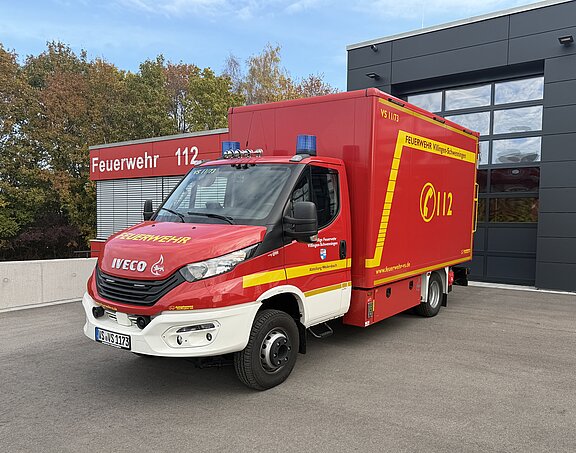 Vor dem Feuerwehrhaus steht ein roter Gerätewagen-Transport der Feuerwehr.